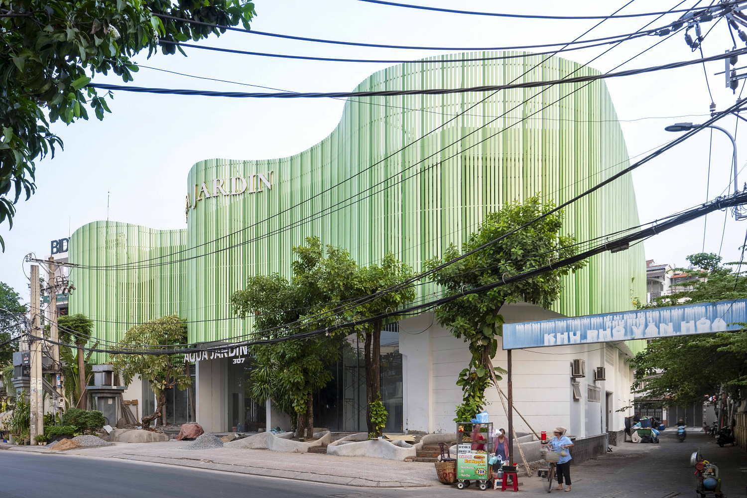 Повторно использованные деревянные панели образуют волнообразный фасад свадебной площадки в аква-жардине во Вьетнаме